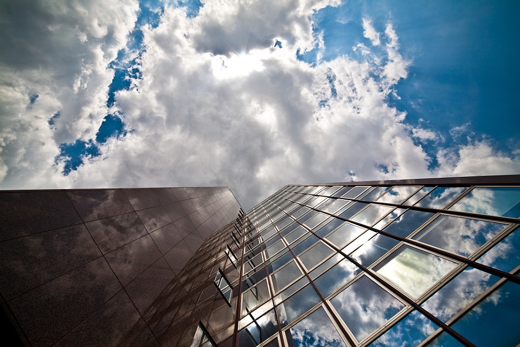 Architektur.jpg - Architektur in Köln - Haus mit teilweiser Glasfassadem, poliertem Stein und schöne Wolken am Himmel